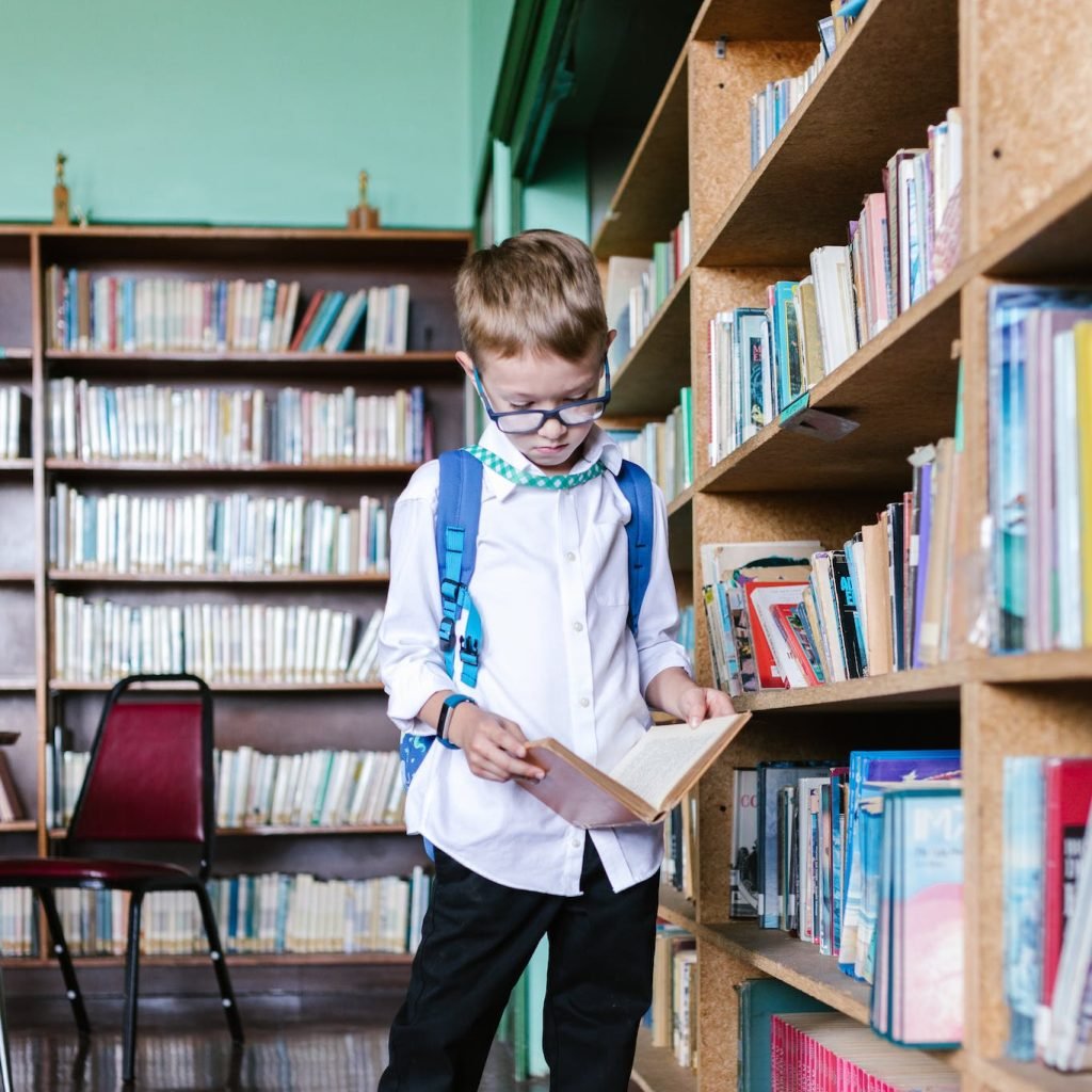 Boy in White Long Sleeve Shirt in the Library